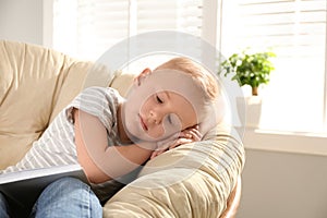 Cute little boy sleeping in papasan chair