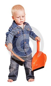 Cute little boy standing holding dustpan and brush isolated.