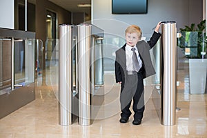 A cute little boy in a suit at the entrance to the