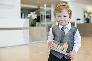 A cute little boy in a suit and tie with a toy