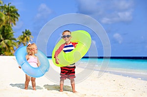 Cute little boy and toddler girl play on beach