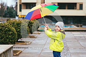 Cute little boy walking in city on rainy day. Child with umbrella outdoors