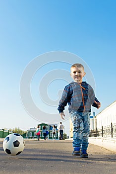 Cute little boy is walking in a park with his parents