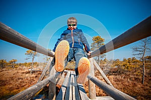 Cute little boy walking on trail in swamp, Kemeri national park, Latvia photo