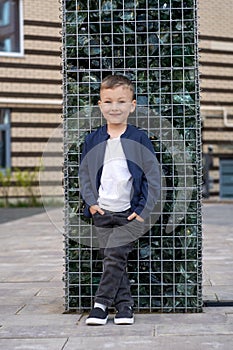 Cute little boy on wall with glass stones background. Kids fashion concept