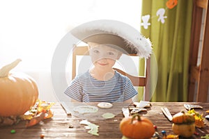 Cute little boy wearing pirate costume on Halloween trick or treat. Kids carving pumpkin lantern. Children celebrate