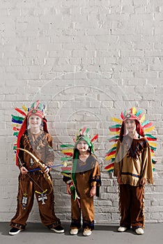 cute little boys in indigenous costumes standing against white
