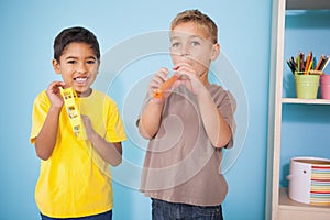 Cute little boys playing musical instruments in classroom