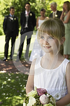 Cute Little Bridesmaid Holding Bouquet In Lawn