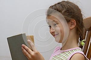 Cute little brunette relaxing and enjoying a good storybook at home