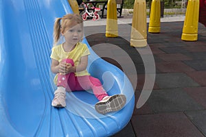 Cute little caucasian child sits on a slide after riding