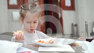 Cute little Caucasian girl eating pizza. Hungry child taking a bite from pizza.