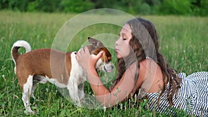 Cute little Caucasian girl pet their dog lying on grass