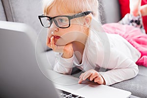 Cute little caucasian girl using laptop