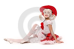 Cute little caucasian girl wearing red skirt, t-shirt with flowers and cowboy hat isolated on white background.