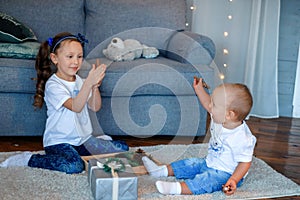 Cute little caucasian kids siblings laughing and playing at home show love and care, small girl sister embrace toddler brother,