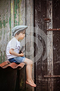 Cute little child, boy, holding big metal key and a book, willin