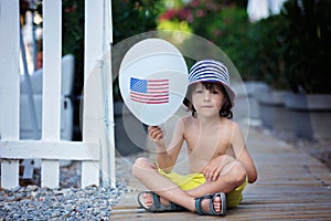 Cute little child, boy, playing with balloon with USA flag