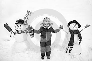 Cute little child boy on snowy field outdoor. Child boy Having Fun in Winter Park. Winter children in frosty winter Park