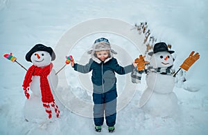 Cute little child boy on snowy field outdoor. Child boy Having Fun in Winter Park. Winter children in frosty winter Park