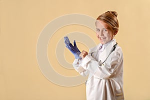 Cute little child in doctor coat with stethoscope and clipboard on lighte background
