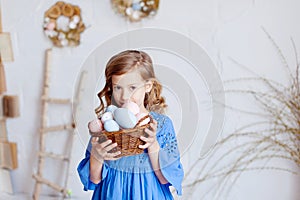 Cute little child on Easter day. Girl holding basket with painted eggs