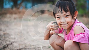 Cute little child girl holding a baby chick in her hand with love and happy