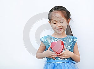 Cute little child girl holding red heart gift box for Valentine`s Day isolated on white background