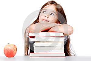 Cute little child girl looking up on the desk at school