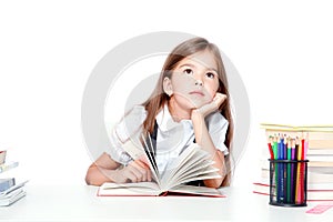 Cute little child girl looking up on the desk at school