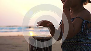 Cute little child girl playing drums on sandy beach.