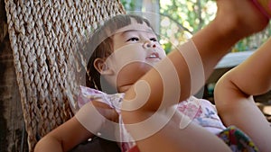 Cute little child girl relaxing and lying on hammock outdoor in the garden.