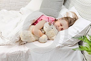 Cute little child girl sleeping with teddy bear