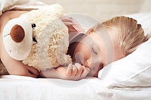 Cute little child girl sleeping with teddy bear