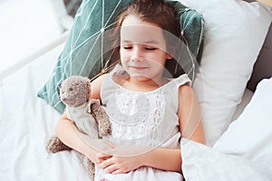 cute little child girl sleeping and watching sweet dreams with her teddy bear