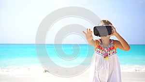 Cute little child girl using VR virtual reality goggles