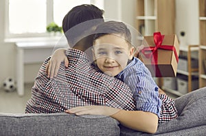 Cute little child giving present to his daddy and wishing him Happy Father's Day