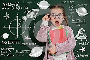 Cute child in glasses near chalkboard with constitutive equations. First time at school photo