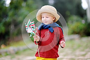 Cute little child holding toy windmill with Italian flag