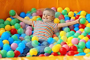 Cute little child playing in ball pit