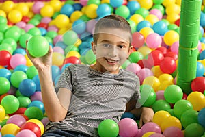 Cute little child playing in ball pit