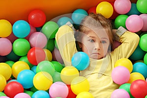 Cute little child playing in ball pit