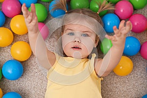 Cute little child playing with balls on floor