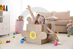 Cute little child playing with cardboard plane