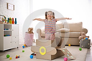 Cute little child playing with cardboard plane