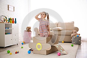 Cute little child playing with cardboard plane