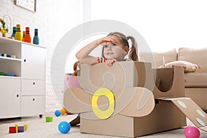 Cute little child playing with cardboard plane