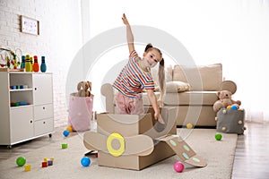 Cute little child playing with cardboard plane