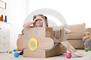 Cute little child playing with cardboard plane