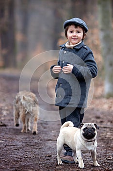 Cute little child, playing with little pet dog in the forest